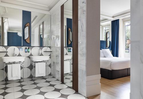 a bathroom with two sinks and a bed at One Shot Recoletos in Madrid