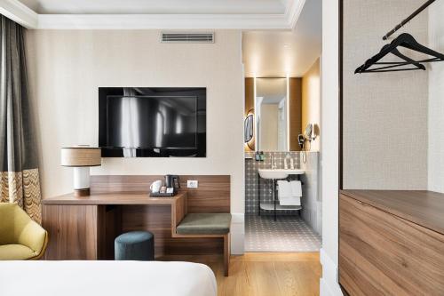 a hotel room with a desk and a television at One Shot Recoletos in Madrid