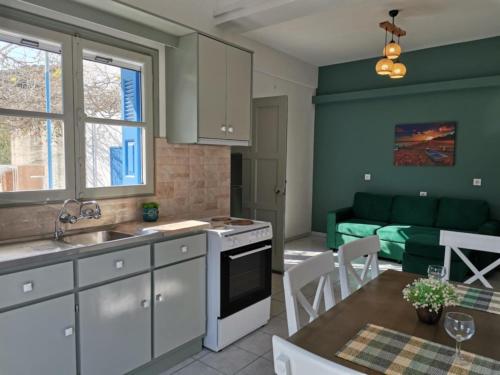 a kitchen and dining room with a couch in the background at Valentino's Apartment 2 in Panormos Kalymnos
