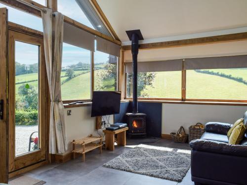 ein Wohnzimmer mit Blick auf ein Feld durch die Fenster in der Unterkunft Heyope Cottage in Llangunllo