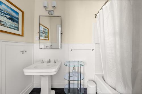 a white bathroom with a sink and a mirror at Lavish Boston Mansion Pool, Gardens, Games, Pond! in Dedham