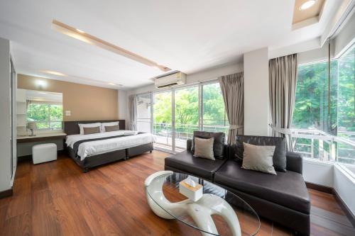 a bedroom with a bed and a couch at Story At Bangkok- 211 Studio with Balcony in Klong Toi