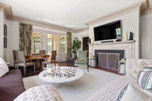 a living room with a couch and a table at Lavish Boston Mansion Pool, Gardens, Games, Pond! in Dedham
