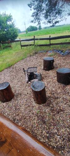 a playground with three logs and a grill and a fence at Pronájem dřevěného mobilheimu Štít in Chlumec nad Cidlinou