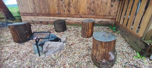 a garden with logs and a bench and a fence at Pronájem dřevěného mobilheimu Štít in Chlumec nad Cidlinou
