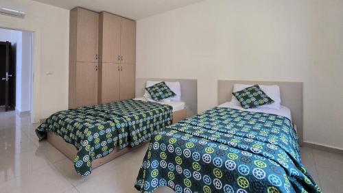 a bedroom with two beds and a cabinet at Tabarja Hills apartment in ‘Ayn aş Şughayrah