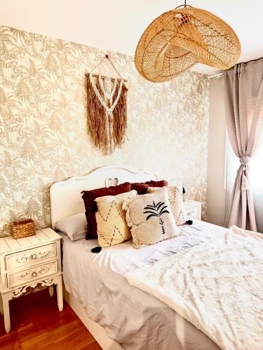 a bedroom with a bed with white sheets and a nightstand at Apartamento centro de Foz con piscina in Foz