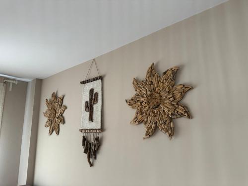 three wooden snowflake ornaments hanging on a wall at Apartamento centro de Foz con piscina in Foz