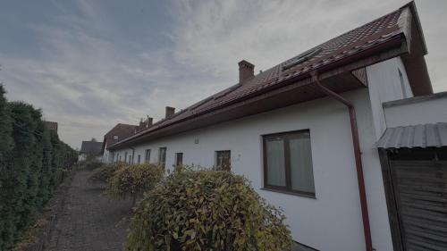 a row of white houses with a driveway at Pokoje Gościnne Lipowa in Czaplinek