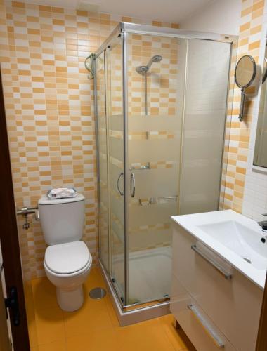 a bathroom with a shower and a toilet and a sink at Apartamento centro de Foz con piscina in Foz