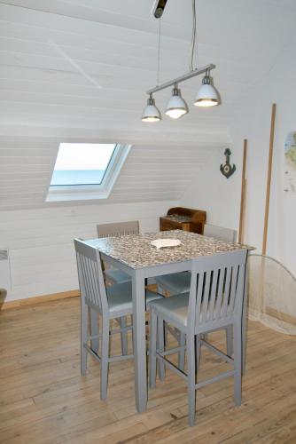 a kitchen with a table and chairs and a window at L'Escale Cayolaise in Cayeux-sur-Mer