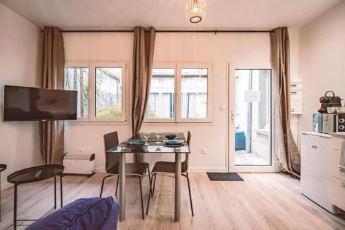 une cuisine et une salle à manger avec une table et des chaises dans l'établissement Socotra - Appartement chaleureux - Hyper-centre, à Reims