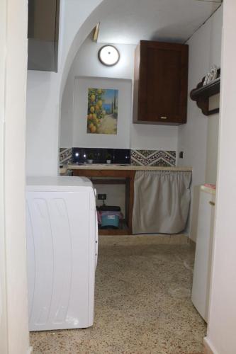 a kitchen with a white refrigerator and a clock on the wall at CASA DOLCE VITA di DeNi in Marsala