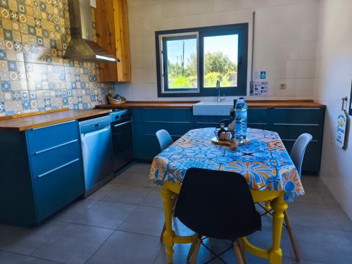 a kitchen with blue cabinets and a table with chairs at Casa rural Chapinheira in Chapinheira
