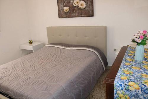 a bedroom with a bed and a table with flowers at CASA DOLCE VITA di DeNi in Marsala