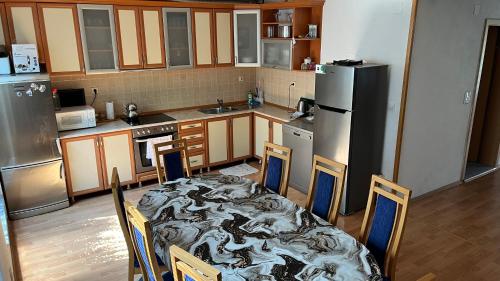 a kitchen with a table with chairs and a refrigerator at Vizbeg Inn in Skopje