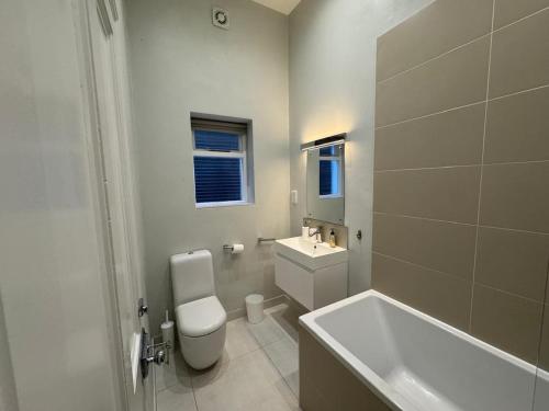 a bathroom with a toilet and a sink and a tub at Charming apartment Belsize Park in London