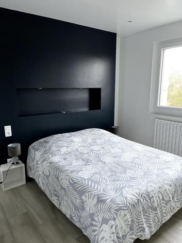 - une chambre avec un lit doté d'un couvre-lit noir et blanc dans l'établissement Appartement cosy avec vue mer, à Saint-Gilles-Croix-de-Vie