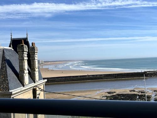 une vue sur une plage et l'océan depuis un immeuble dans l'établissement Appartement cosy avec vue mer, à Saint-Gilles-Croix-de-Vie