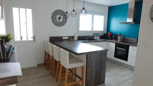 une cuisine avec un îlot et des tabourets de bar dans l'établissement Appartement cosy avec vue mer, à Saint-Gilles-Croix-de-Vie