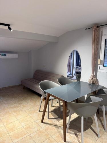 a dining room with a table and chairs and a couch at Kalithea Central View Apartments in Kallithea Halkidikis