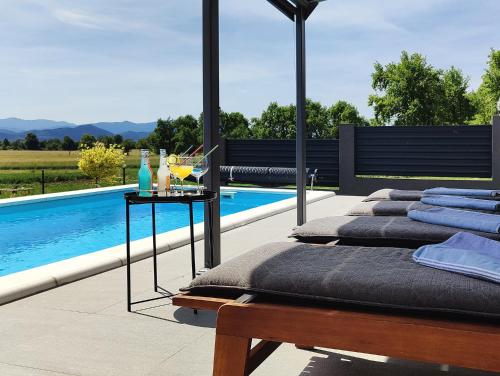 a row of beds sitting next to a swimming pool at Villa Biser Gacke in Sinac