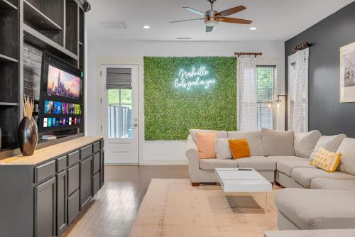 a living room with a couch and a tv at Rooftop Large Backyard Fire Pit Near Downtown Nashville in Nashville