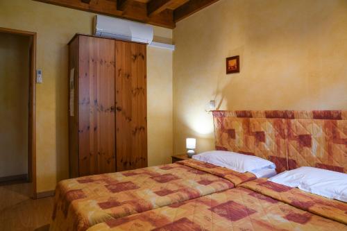 a bedroom with two beds and a wooden cabinet at L'orée du bois in Yenne
