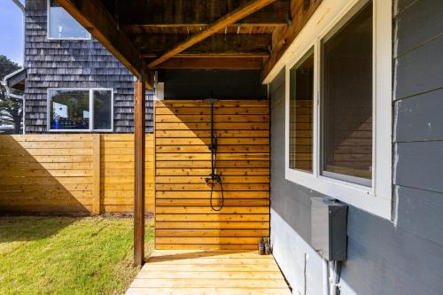 a wooden pergola on the side of a house at Royal Canoe by AvantStay Walk to the Shore Private Yard in Arch Cape