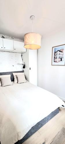 une chambre avec un grand lit blanc dans une pièce dans l'établissement Grand studio avec terrasse - Gare - Metro - Wifi, à Toulouse