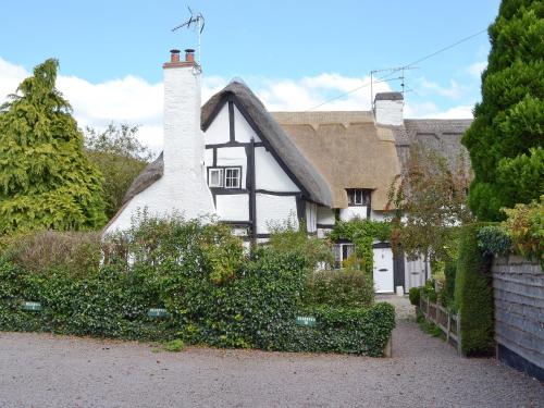 an old black and white house with a thatched roof at Hathaway Hamlet in Stratford-upon-Avon