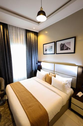 Un dormitorio con una cama grande y una ventana. en Ringruby Hotel, Eso Close, en Ikeja