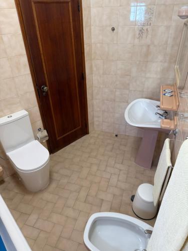 a bathroom with a toilet and a bidet and a sink at Praia do Vau-Apartamentos Mar Azul in Bicas