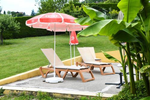 two chairs and an umbrella on a patio at L'orée du bois in Yenne