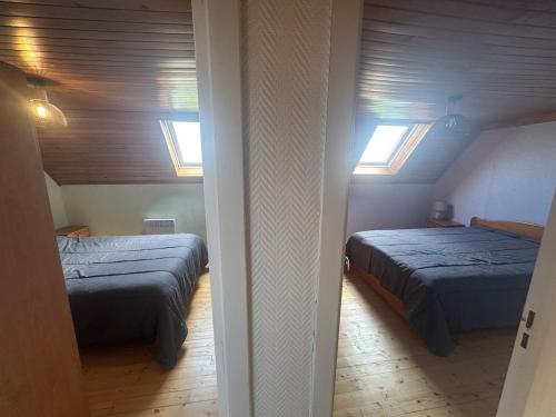une chambre avec deux lits et deux fenêtres dans l'établissement Maison de vacances Crozon 2ch - jardin clos, à Crozon