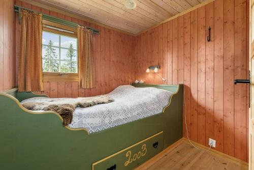 Un dormitorio con una cama en una habitación con paredes de madera. en Enjoy Traditional, Norwegian Cabin Coziness, en Traut