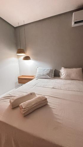 a white bed with two towels on top of it at Lençóis Maranhenses - Casa Armonia in Santo Amaro