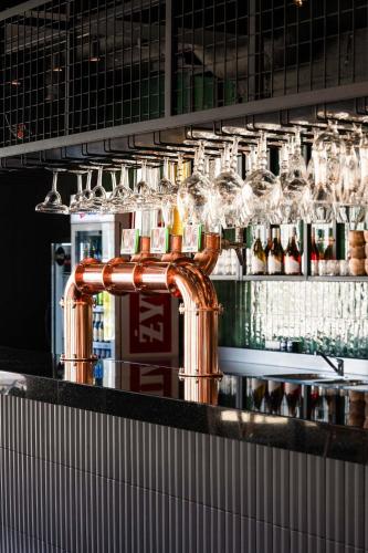 a bar with a copper pipe and wine glasses at Olivina Park Spa - domki z dostępem do krytego basenu, saun, wyżywienia i atrakcji dla dzieci in Niechorze
