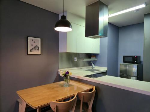 a kitchen with a wooden table and some chairs at Interlaken Stay in Gapyeong