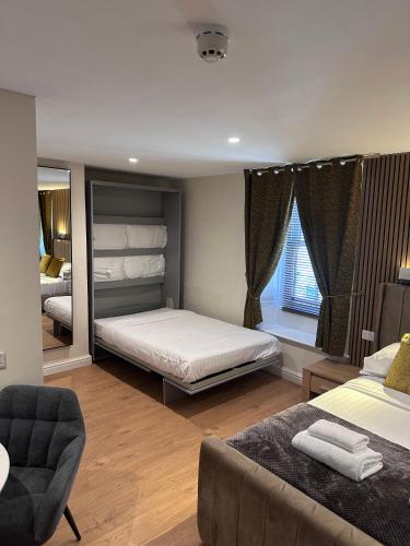 a bedroom with a bed and a couch and a mirror at Laburnum Guest House at Bistro En Glaze in Wylam