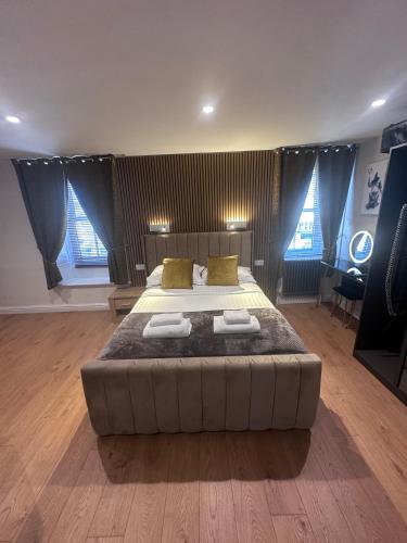a bedroom with a large bed in a room with windows at Laburnum Guest House at Bistro En Glaze in Wylam