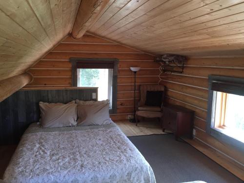 a bedroom with a bed in a log cabin at Cabins Over Crag Lake in Carcross