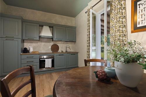 a kitchen with a table with a vase of flowers at La Meirana - Cottage delle Vigne in Gavi