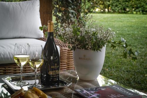 a bottle of wine and glasses on a table at La Meirana - Cottage delle Vigne in Gavi