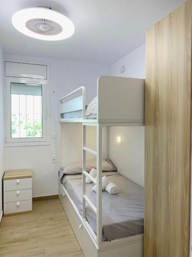 Un dormitorio con dos literas y una ventana. en Delícies Mar apartamento, en Sant Carles de la Ràpita