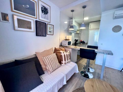 a living room with a couch and a kitchen at Stylish and comfortable one bedroom with sea view in Torremolinos