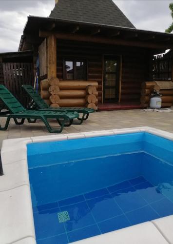 a house with a blue swimming pool in front of a house at Дом с сауной и басейном на Теремках in Hatne