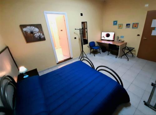 a blue bed in a room with a table and a desk at Copenaghen-Rooms in Sassari