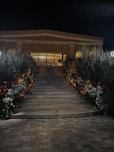 a set of stairs leading to a building with flowers at Hotel Malvina in Sînnicolau Mare