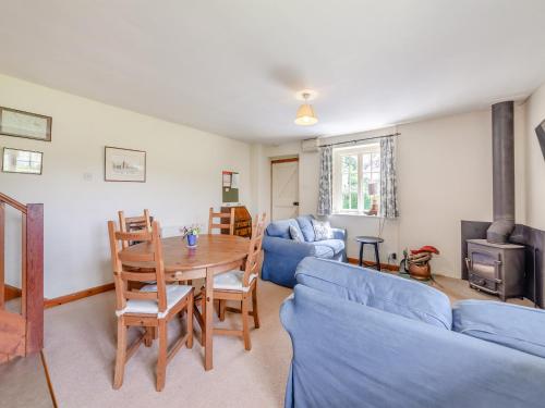 a living room with a table and a blue couch at Stable Cottage - 26032 in Wark